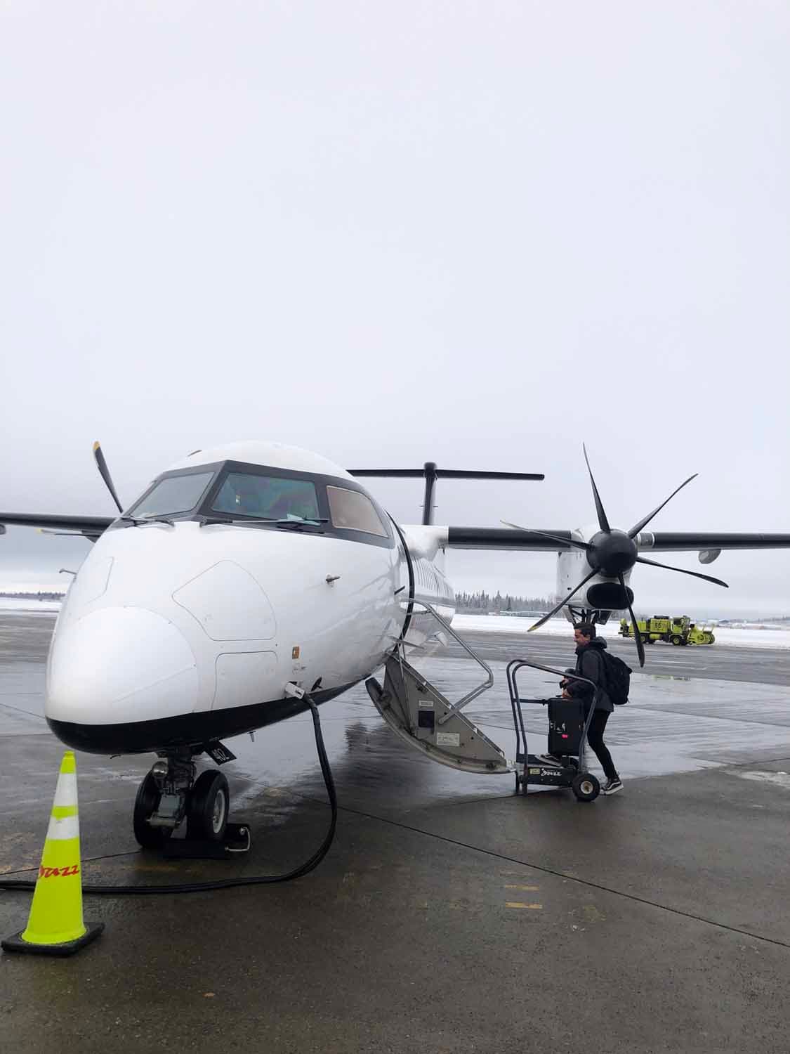 video camera person boards a plane to a remote location.
